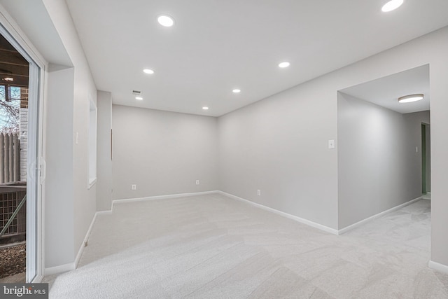 below grade area with recessed lighting, light colored carpet, and baseboards