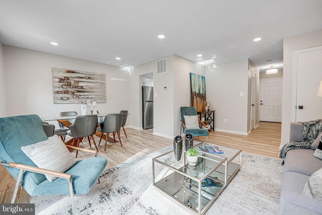 living area featuring visible vents, recessed lighting, baseboards, and wood finished floors