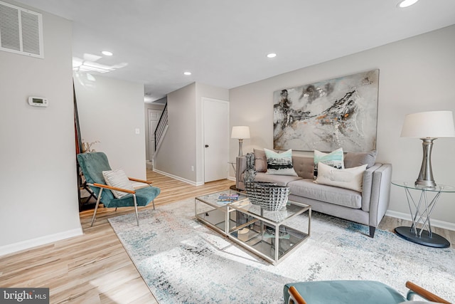 living area with visible vents, recessed lighting, stairs, and wood finished floors