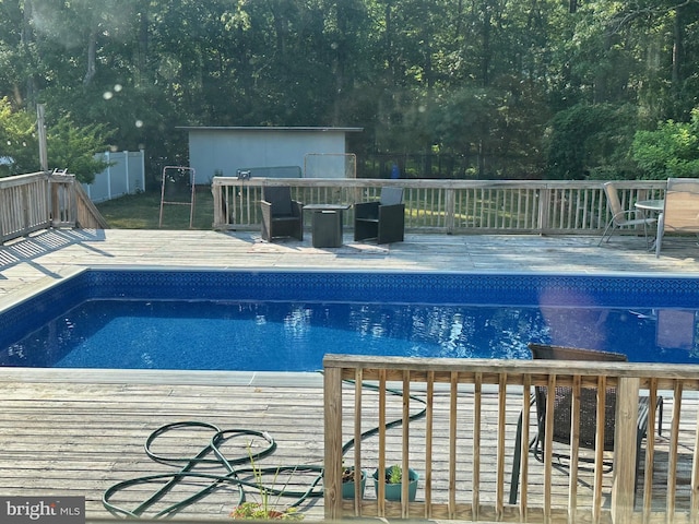 outdoor pool with a deck and fence