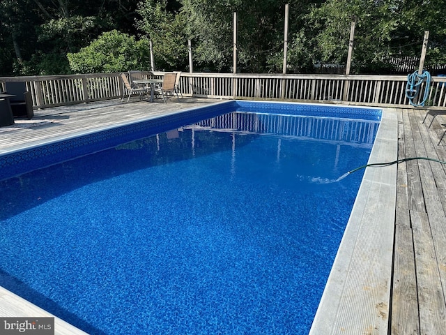 view of pool featuring outdoor dining space, a fenced in pool, and a deck