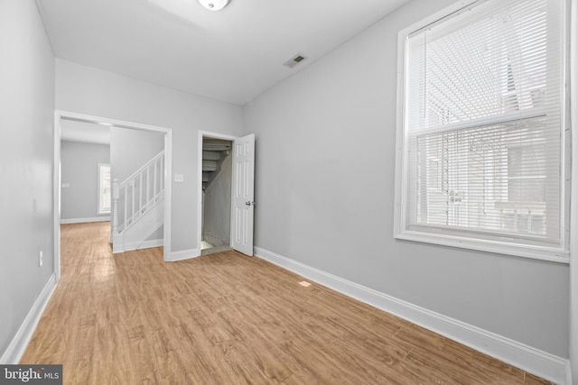 unfurnished bedroom with visible vents, baseboards, and wood finished floors