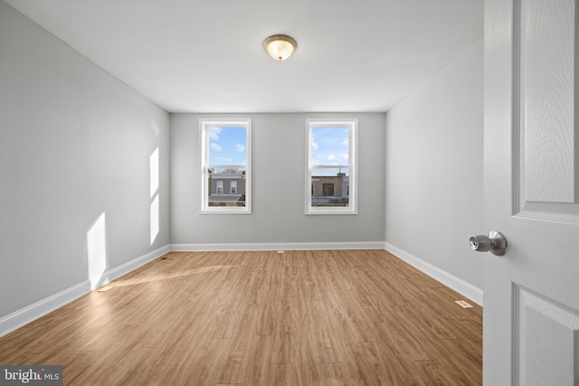 unfurnished room with wood finished floors and baseboards