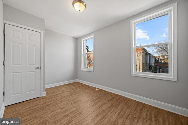 unfurnished bedroom featuring wood finished floors and baseboards