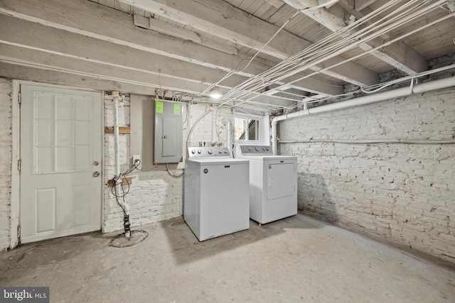 below grade area with electric panel and washer and clothes dryer