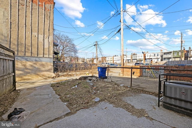 view of yard featuring fence and central air condition unit