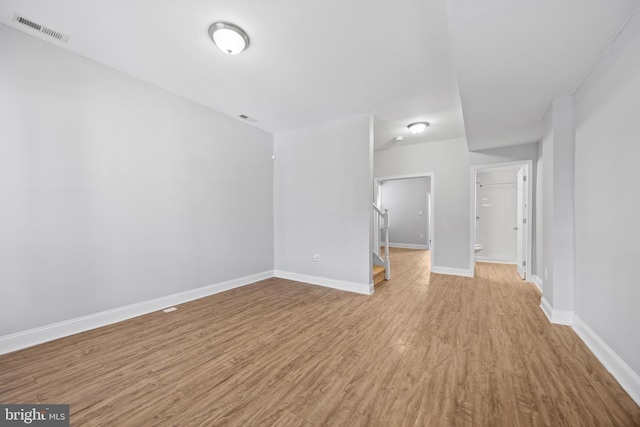 empty room with baseboards, visible vents, and wood finished floors