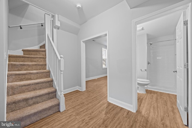 stairway featuring wood finished floors and baseboards