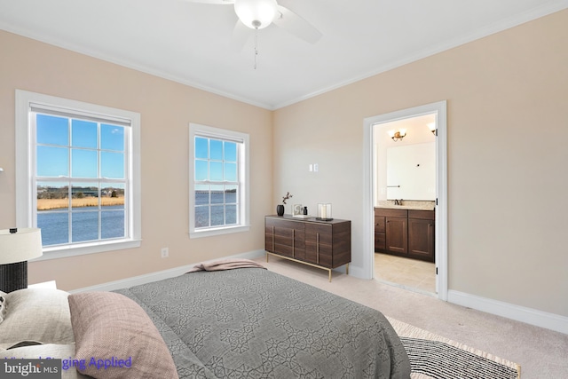 bedroom with baseboards, a sink, ornamental molding, light colored carpet, and connected bathroom