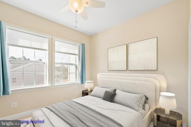 bedroom with a ceiling fan and baseboards