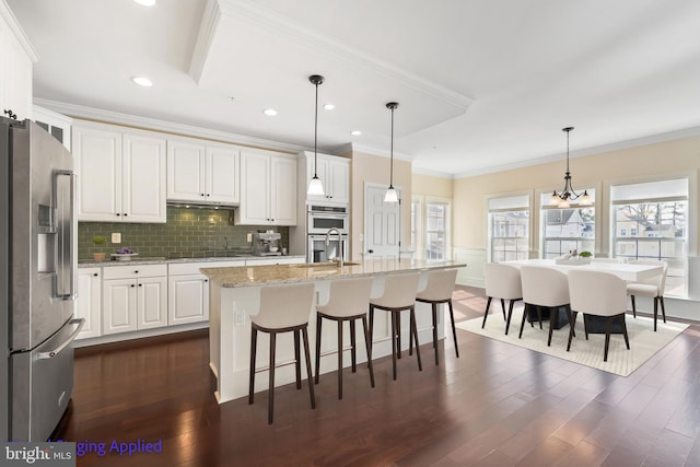 kitchen with dark wood-style floors, white cabinets, appliances with stainless steel finishes, crown molding, and backsplash