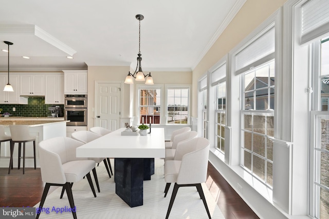 dining space featuring a notable chandelier, recessed lighting, crown molding, and wood finished floors