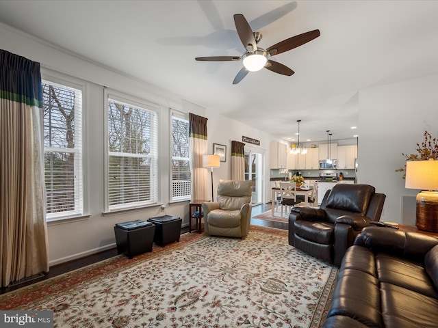 living room featuring ceiling fan, wood finished floors, visible vents, and baseboards