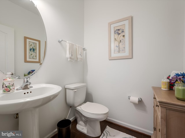 bathroom featuring wood finished floors, toilet, and baseboards