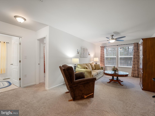 living area featuring carpet flooring, a ceiling fan, and baseboards