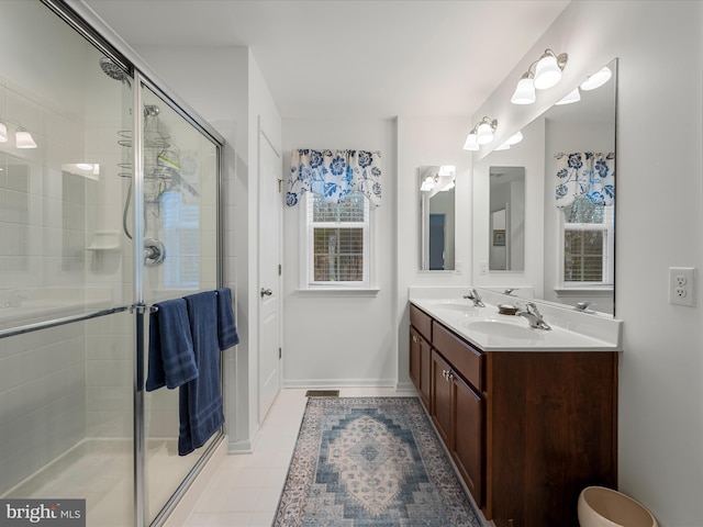 bathroom with a shower stall, a sink, and tile patterned floors