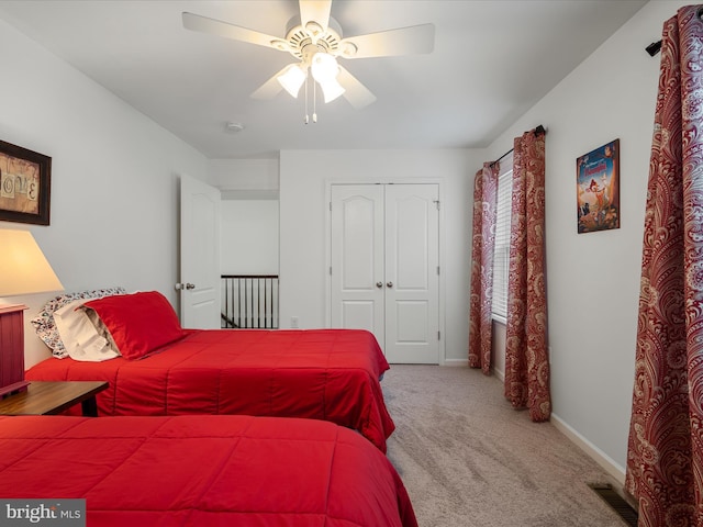 bedroom featuring ceiling fan, carpet floors, visible vents, baseboards, and a closet