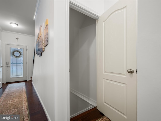 corridor featuring baseboards, dark wood finished floors, and crown molding