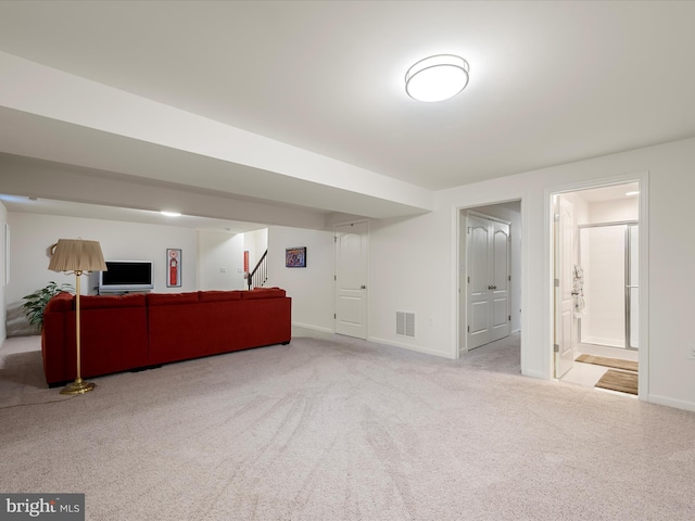 unfurnished living room with carpet, visible vents, baseboards, and stairs