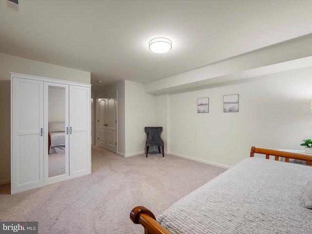 carpeted bedroom featuring a closet, visible vents, and baseboards