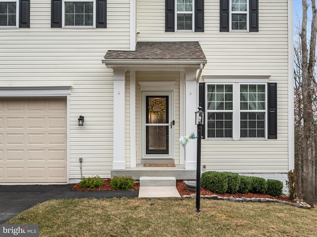 entrance to property featuring a garage and a shingled roof