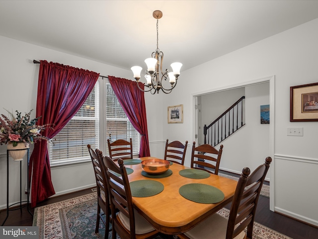 dining room with a chandelier, wood finished floors, and baseboards