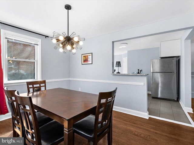 dining area with an inviting chandelier, baseboards, and wood finished floors