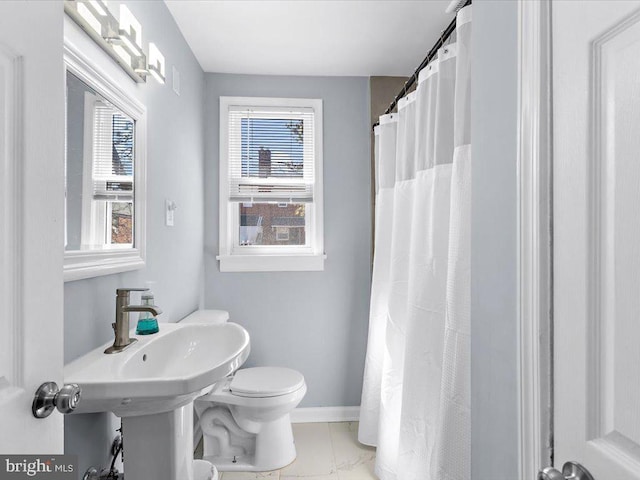 full bath with a shower with curtain, baseboards, and toilet