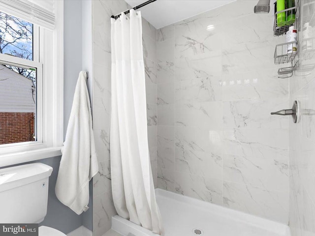 bathroom with a shower stall and toilet