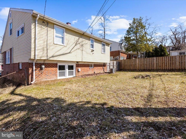 rear view of house with a yard, fence, and central air condition unit