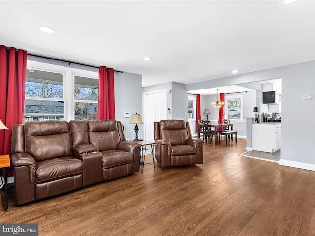 living room with a notable chandelier, recessed lighting, wood finished floors, and baseboards