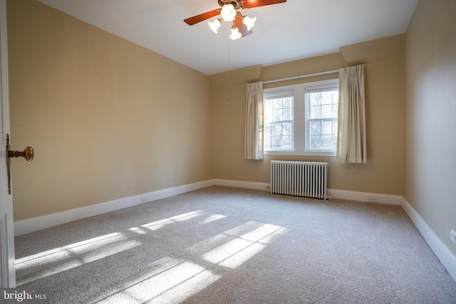 carpeted spare room with radiator heating unit, a ceiling fan, and baseboards