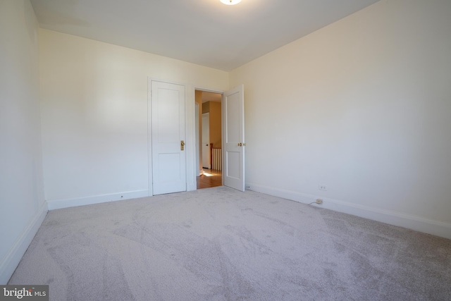 carpeted spare room featuring baseboards