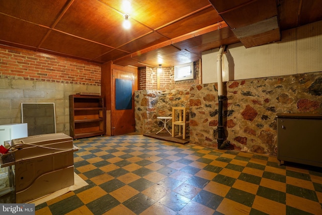 below grade area featuring concrete block wall and tile patterned floors