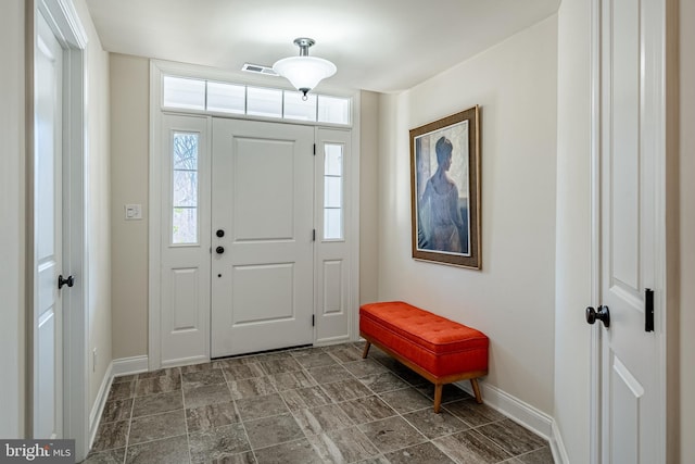 entryway with stone finish floor, baseboards, and visible vents