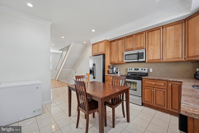 kitchen featuring stainless steel appliances, light tile patterned flooring, and brown cabinets