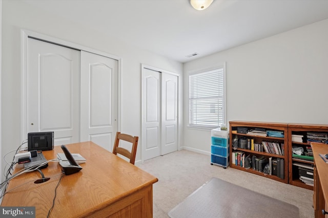 office space featuring carpet flooring, visible vents, and baseboards