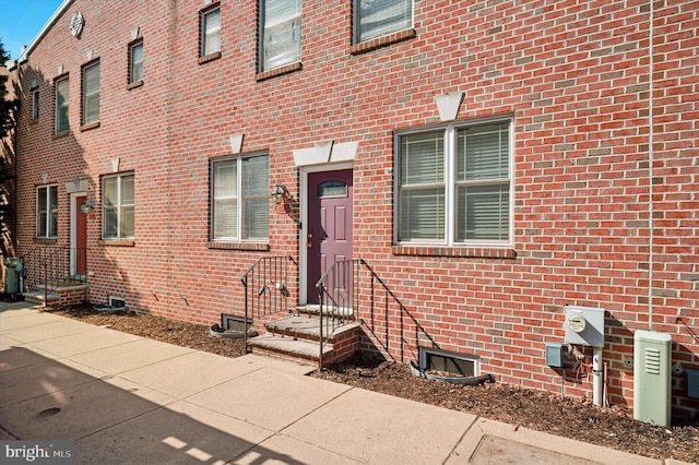 doorway to property with brick siding