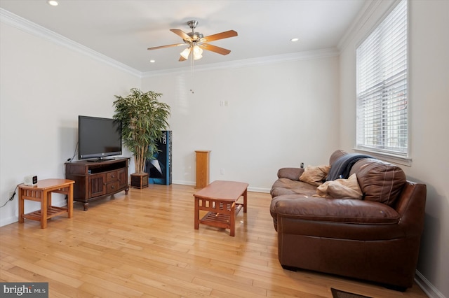 living area with ornamental molding, light wood-style flooring, and baseboards