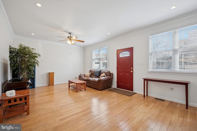 interior space with baseboards, light wood finished floors, visible vents, and crown molding