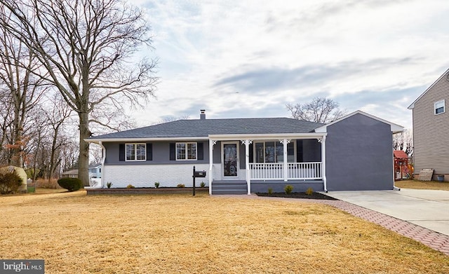 single story home featuring covered porch, concrete driveway, brick siding, and a front yard