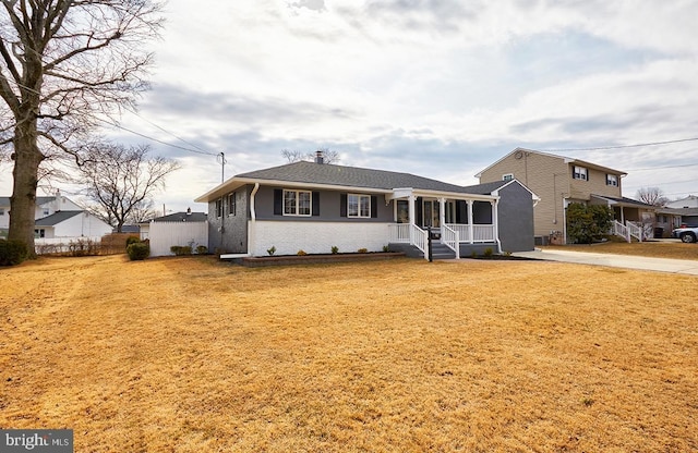 ranch-style house featuring a front yard and covered porch