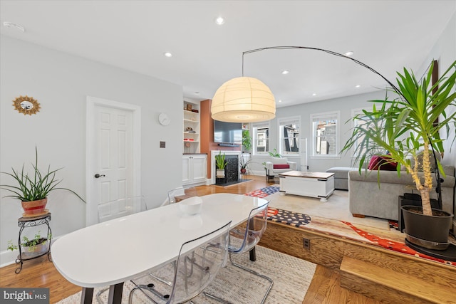 dining area with recessed lighting, baseboards, built in features, and light wood finished floors