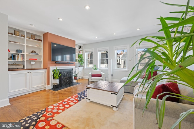 living area featuring recessed lighting, baseboards, light wood-style flooring, and a fireplace