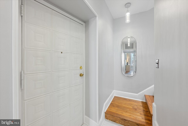 foyer entrance featuring baseboards and wood finished floors