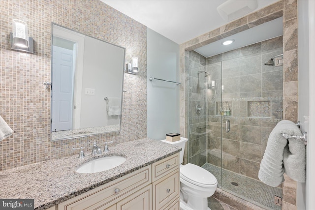 full bath with decorative backsplash, toilet, a stall shower, and vanity