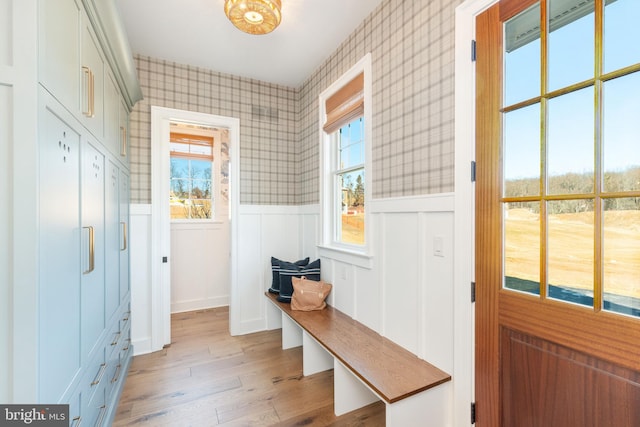 mudroom with light wood-type flooring, a wainscoted wall, and wallpapered walls