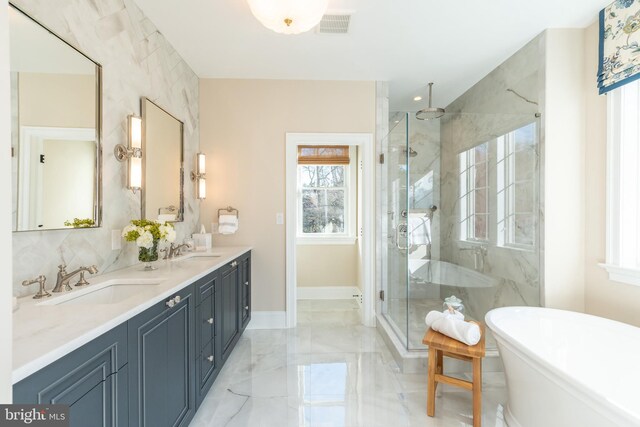 full bath with marble finish floor, a marble finish shower, a sink, and a soaking tub