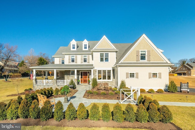 view of front of property with stone siding, a porch, and a front lawn