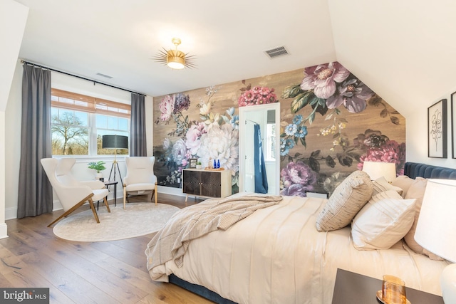 bedroom featuring wood-type flooring, visible vents, and baseboards